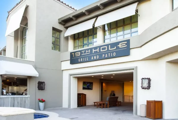 Exterior view of the '19th Hole Grill and Patio' building on a sunny day.