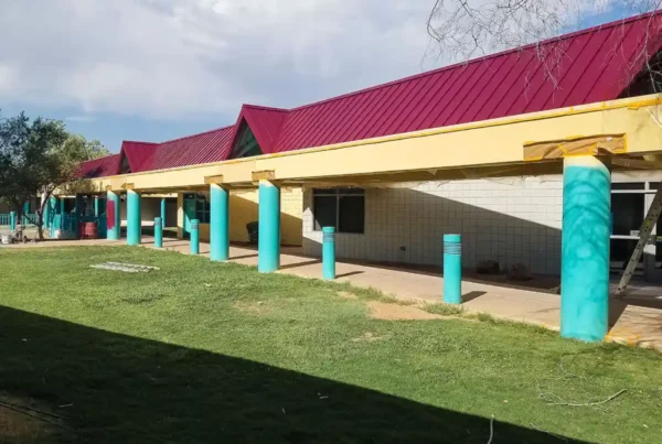 Exterior view of a building with freshly applied paint, showcasing a modern color scheme that highlights architectural details.