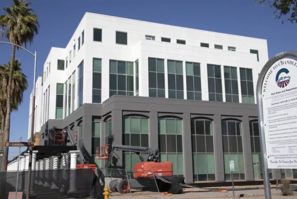 Exterior view of a freshly painted commercial building, featuring modern architecture with clean lines and vibrant colors under clear blue skies.